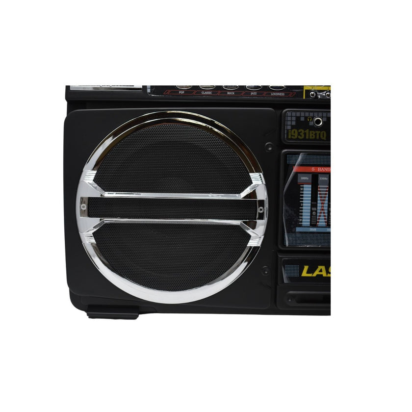 Close-up of a black boombox. The image shows a large circular speaker covered with a mesh grille on the left side, and part of the control panel and screen on the right. The boombox has metallic accents and small buttons.